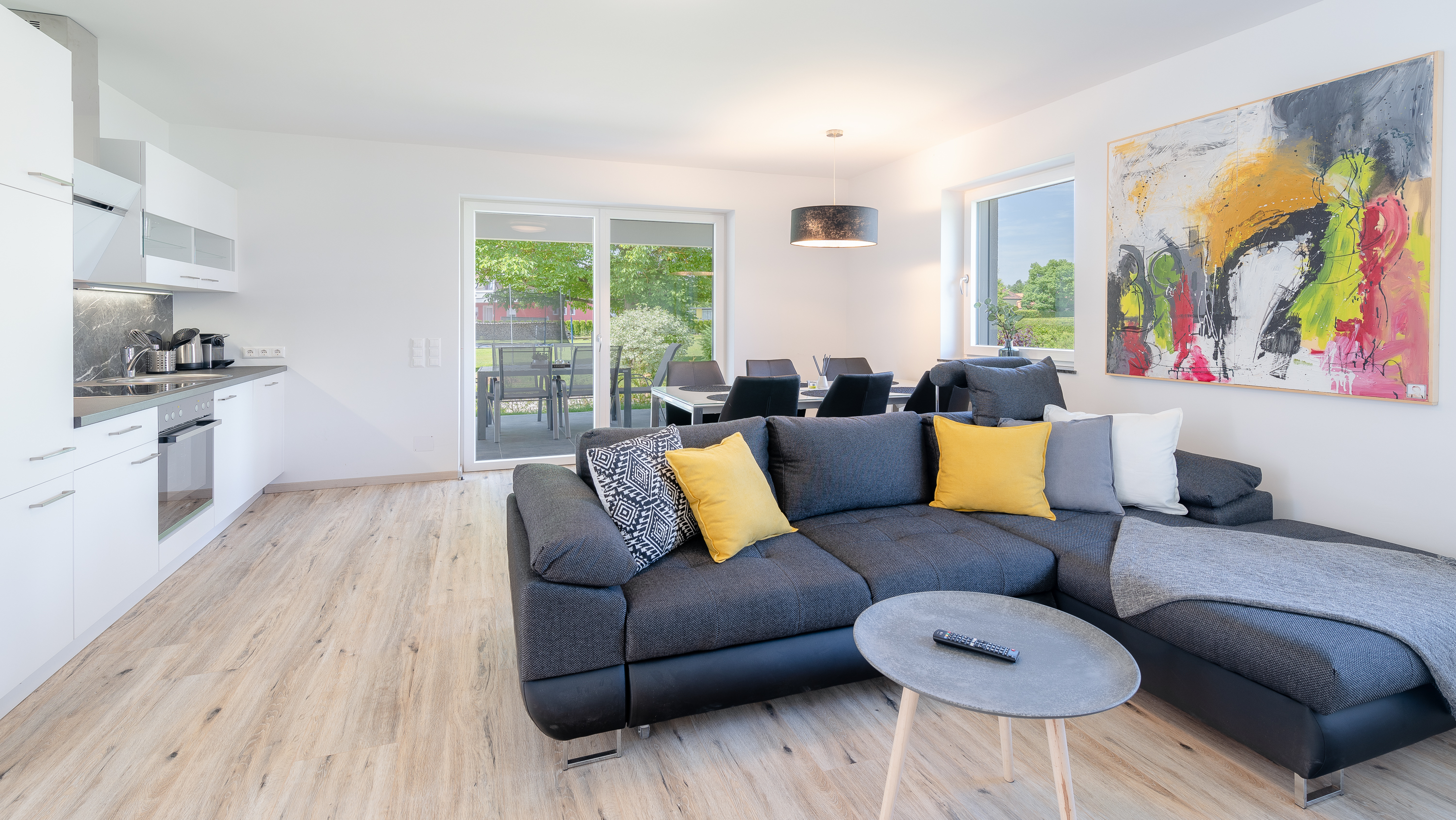 Wohnzimmer mit Couch und offener Küche – Ferienhaus Klopeiner See