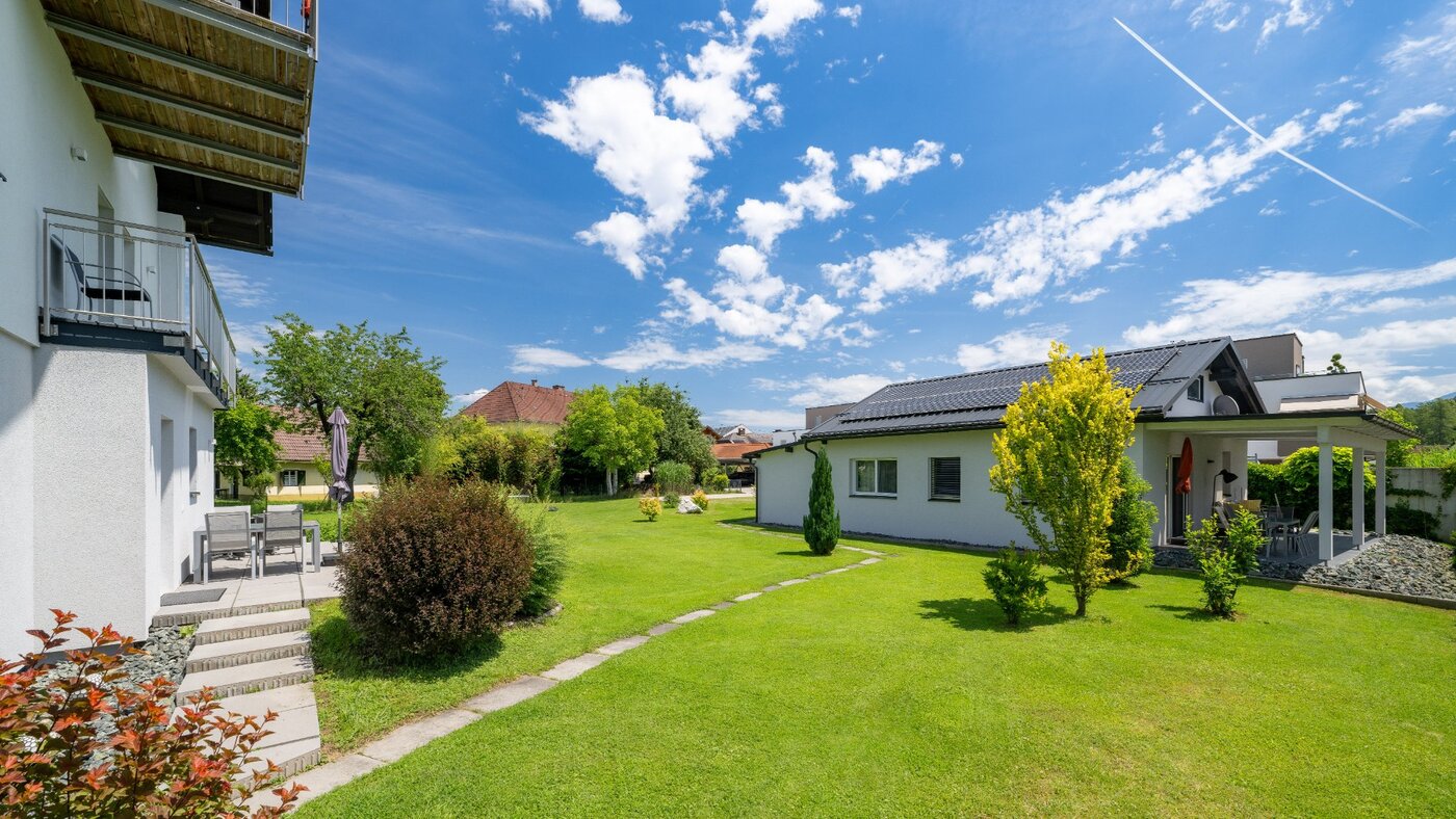 Gepflegter Garten mit Blick auf Apartmenthaus und Ferienhaus mit Terrasse