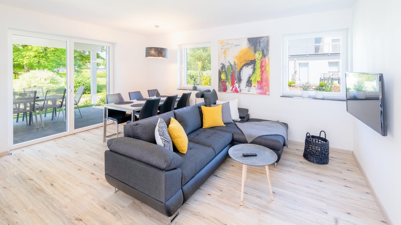 Modernes Wohnzimmer im Ferienhaus am Klopeiner See mit großer Couch und Terrassenzugang
