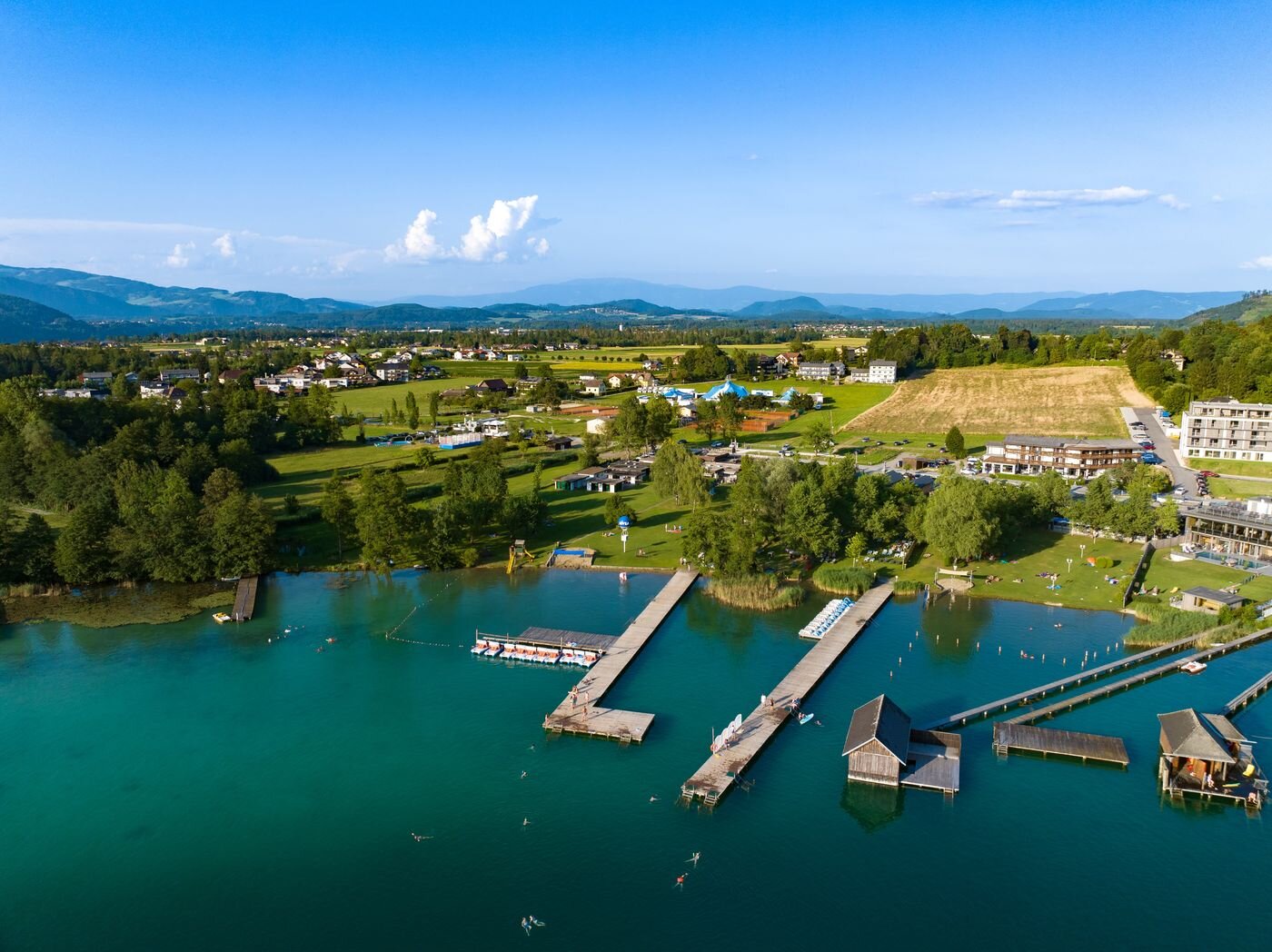 Strandbad am Klopeiner See mit Holzstegen, Liegewiese und türkisem Wasser im Sommer